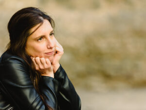 mulher insegura com as mãos no queixo